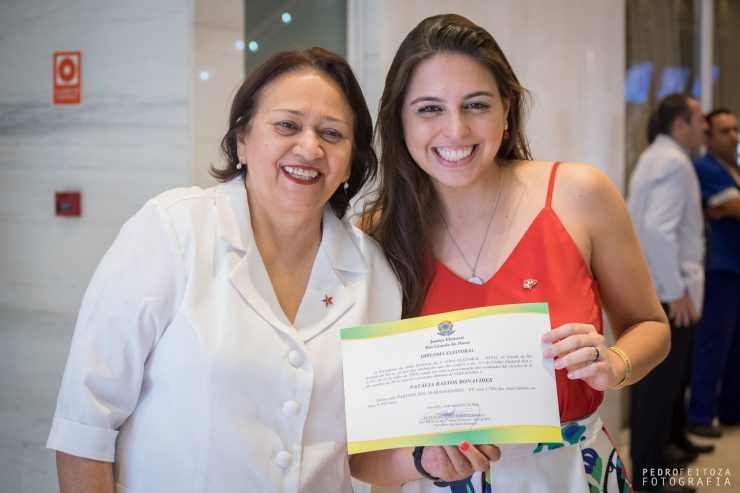A senadora Fátima Bezerra e a vereadora Natália Bonavides segurando o diploma do mandato da vereadora.